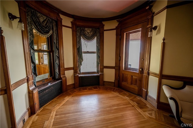 entryway with crown molding and light hardwood / wood-style flooring