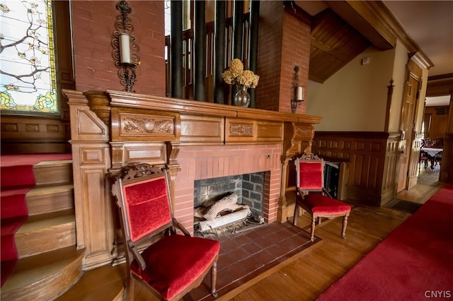 living area with lofted ceiling with beams, a fireplace, and dark hardwood / wood-style flooring