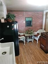 interior space featuring sink, hardwood / wood-style flooring, and brick wall