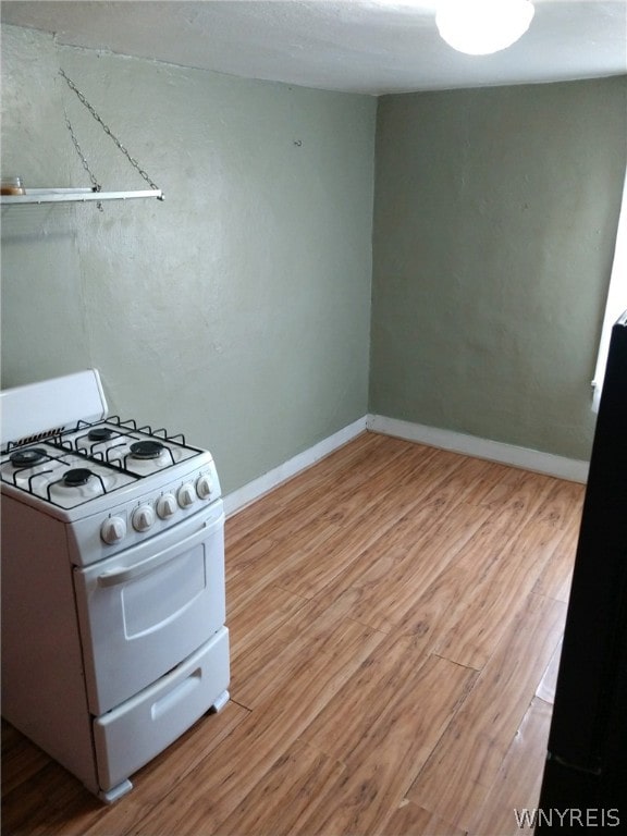 kitchen featuring white range with gas stovetop and light wood-type flooring