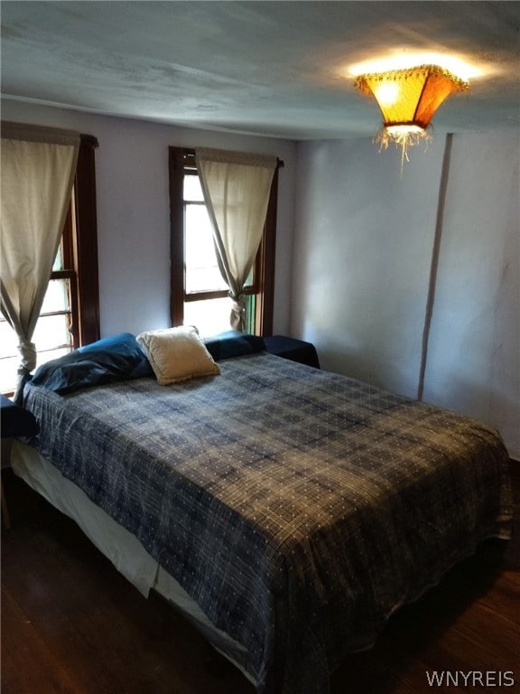 bedroom with dark hardwood / wood-style floors