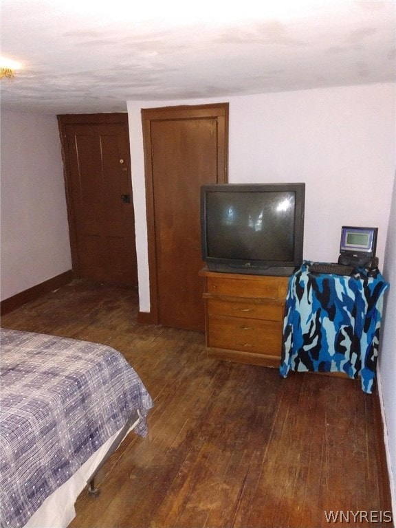 bedroom with dark hardwood / wood-style floors