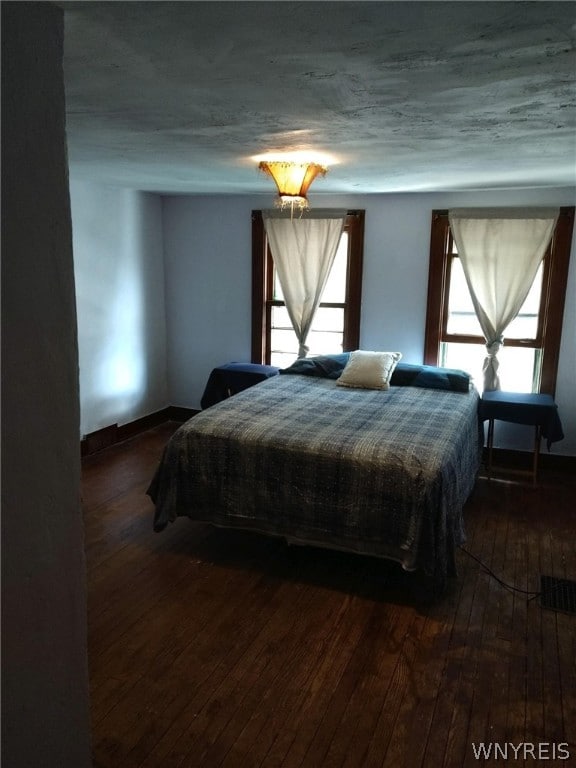 bedroom with dark wood-type flooring