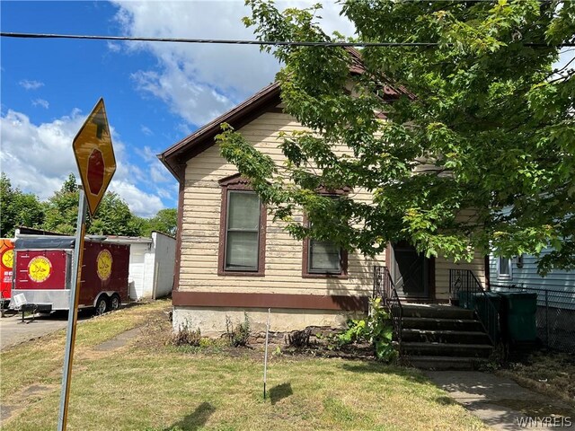 view of front of home with a front lawn and an outdoor structure