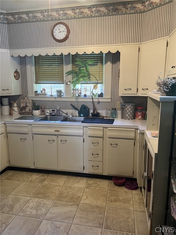 kitchen featuring a healthy amount of sunlight, sink, tasteful backsplash, and light tile floors