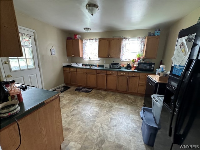 kitchen with sink, black appliances, and light tile floors