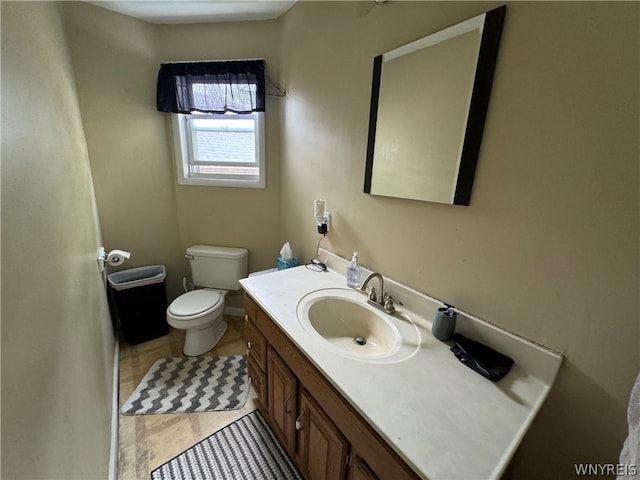 bathroom with vanity with extensive cabinet space, toilet, and tile floors