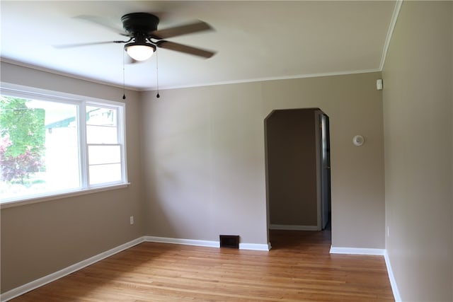 spare room with light hardwood / wood-style floors, ornamental molding, and ceiling fan