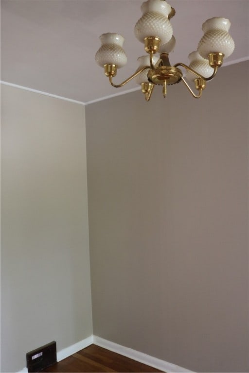 empty room featuring wood-type flooring and ornamental molding