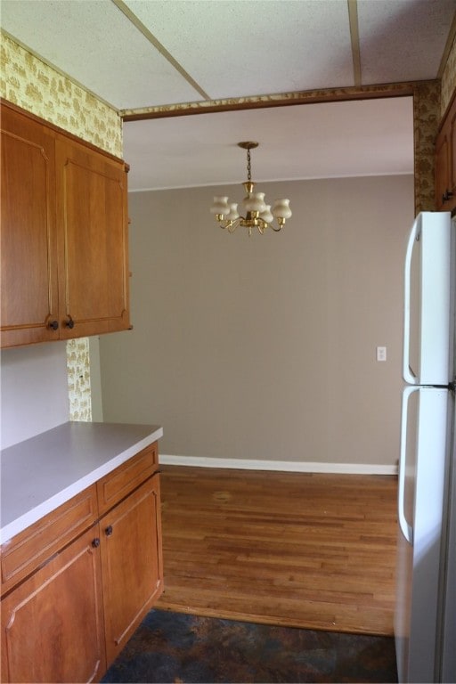 kitchen featuring a notable chandelier, white refrigerator, dark hardwood / wood-style floors, and decorative light fixtures