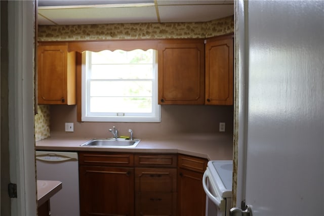 kitchen featuring sink, stainless steel fridge, white dishwasher, and stove