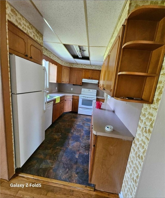 kitchen with dark tile patterned flooring and white appliances