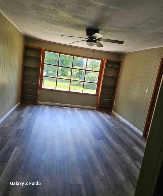 spare room with a textured ceiling, ceiling fan, hardwood / wood-style flooring, and built in shelves