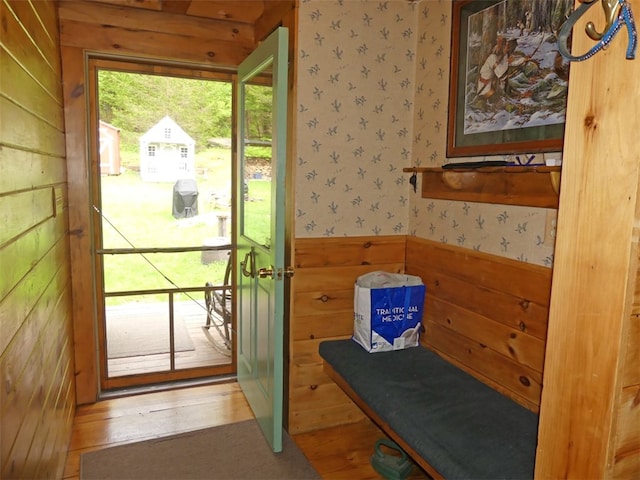 doorway with wood walls and hardwood / wood-style flooring