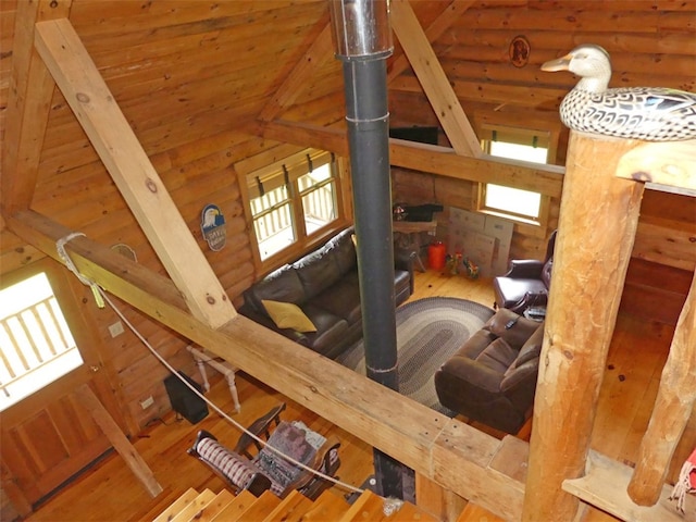 interior space featuring vaulted ceiling, log walls, hardwood / wood-style flooring, and wood ceiling