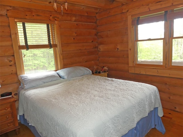 bedroom featuring multiple windows and rustic walls