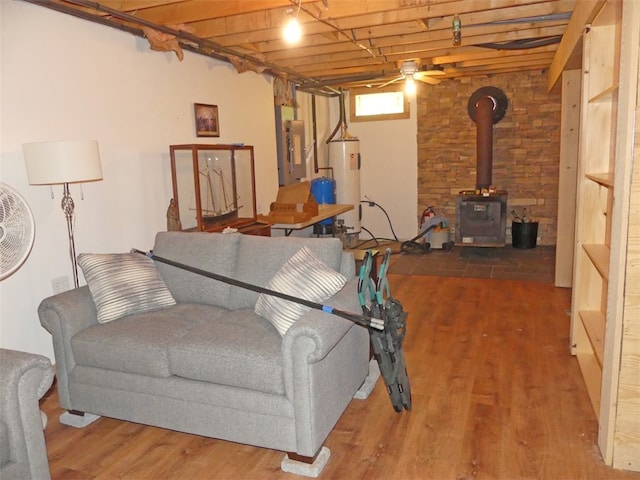 living room featuring a wood stove, ceiling fan, wooden ceiling, hardwood / wood-style floors, and electric water heater