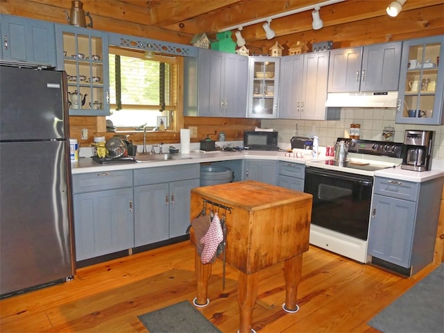 kitchen with electric stove, light wood-type flooring, gray cabinets, sink, and stainless steel refrigerator