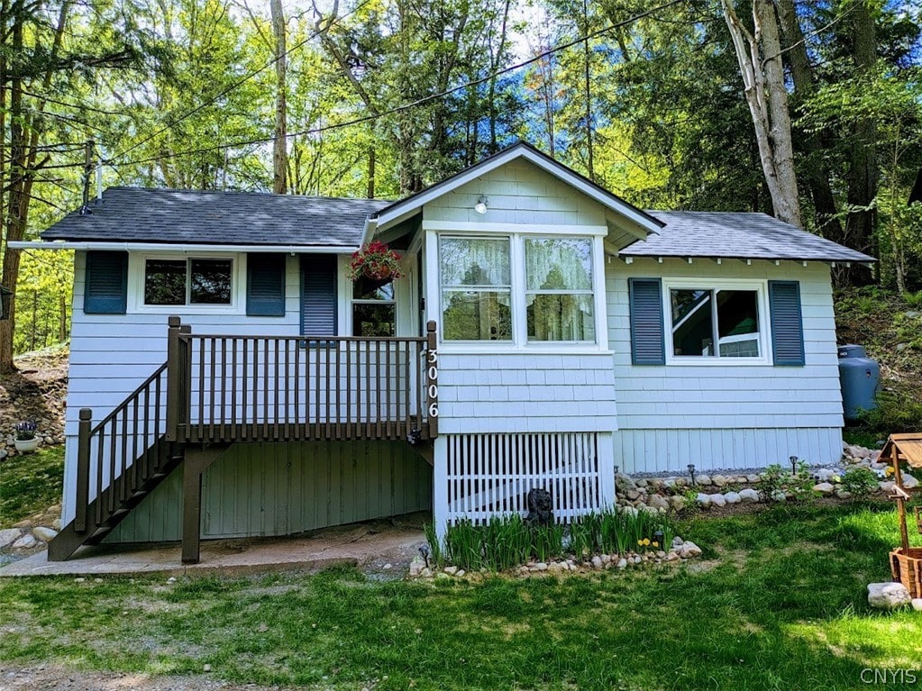 view of front facade with a front yard and a deck