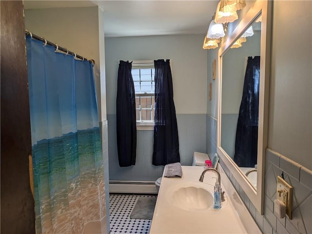 bathroom featuring baseboard heating, vanity, tile walls, and toilet