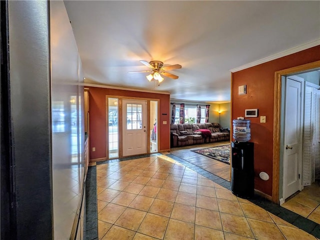 tiled entrance foyer featuring ceiling fan and crown molding