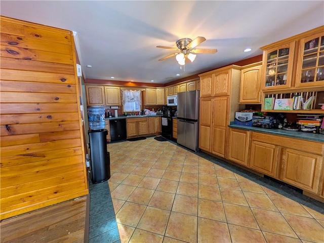 kitchen featuring light tile patterned floors, black dishwasher, stainless steel refrigerator, and stove