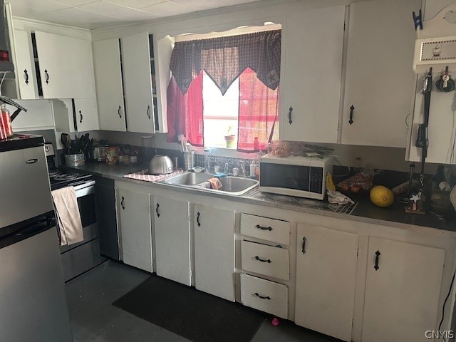 kitchen with appliances with stainless steel finishes, white cabinetry, and sink