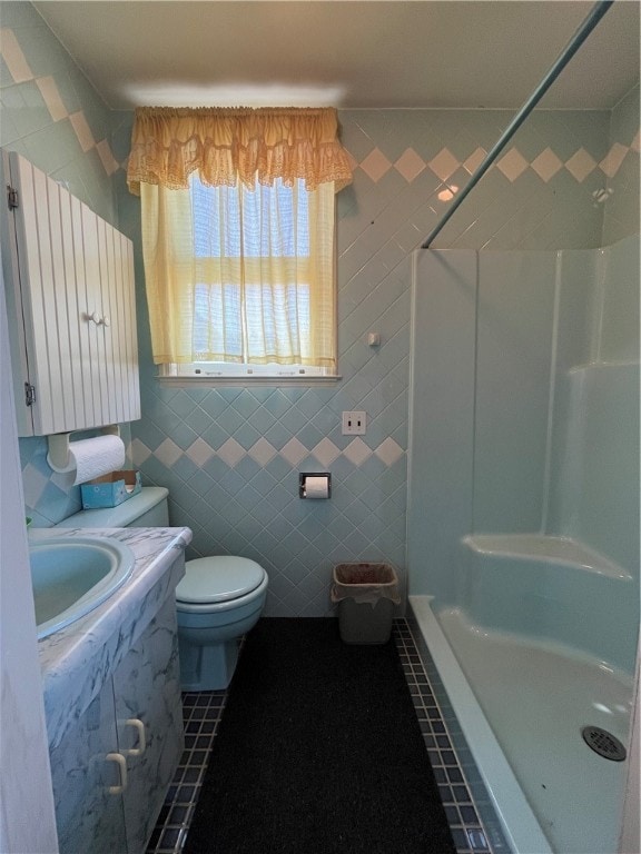 bathroom featuring tile patterned floors, toilet, and a shower