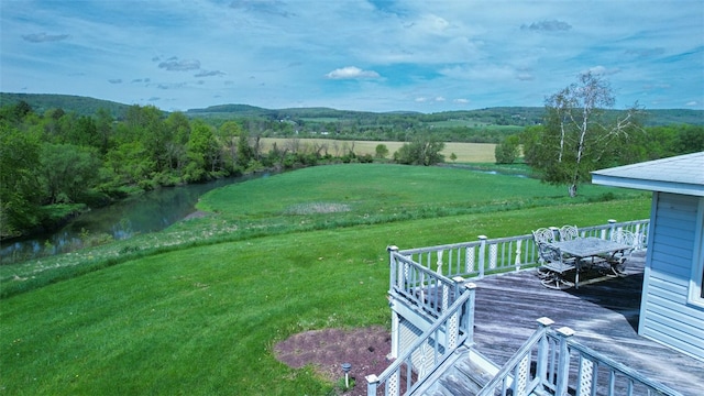 view of yard with a deck with water view