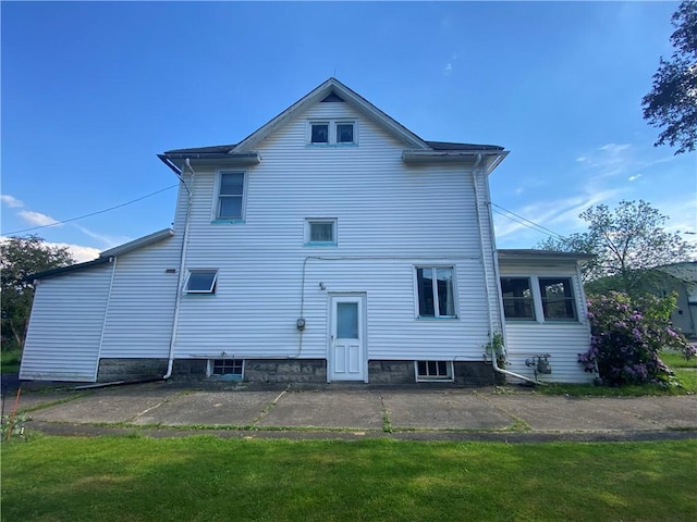 back of house featuring a lawn and a patio area