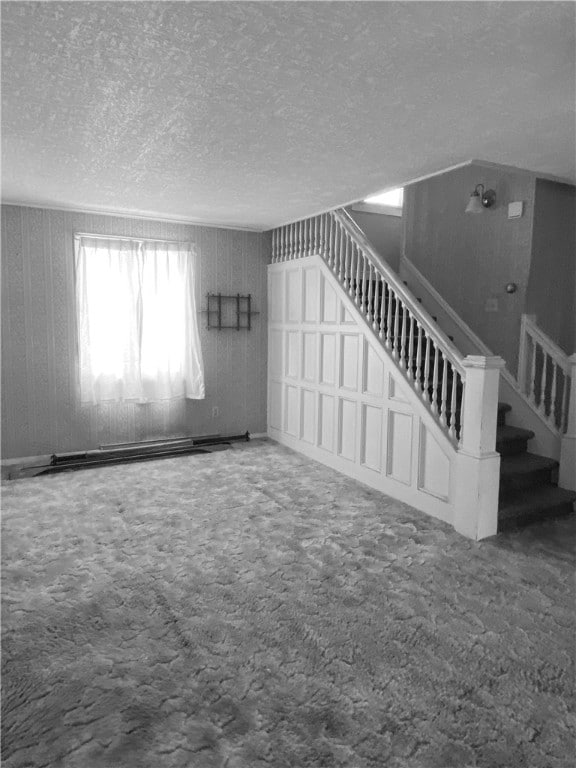 unfurnished living room featuring carpet flooring and a textured ceiling