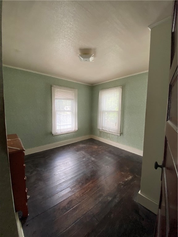 unfurnished room featuring crown molding and dark wood-type flooring