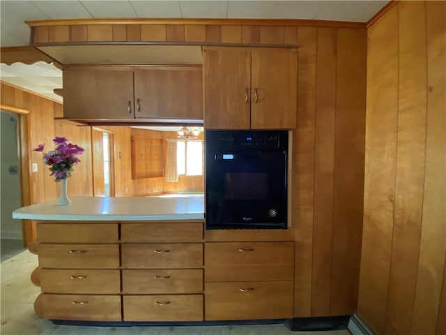 kitchen with oven and wood walls