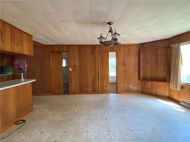 kitchen featuring wood walls, hanging light fixtures, and an inviting chandelier