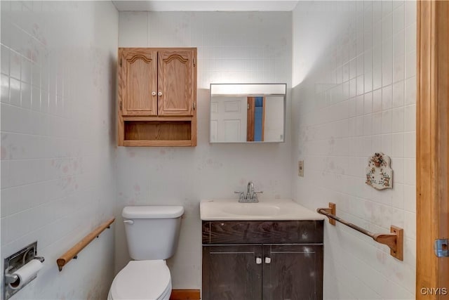 bathroom with vanity, tile walls, and toilet