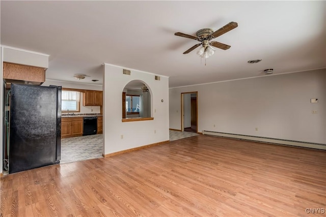 unfurnished living room with sink, ceiling fan, baseboard heating, ornamental molding, and light hardwood / wood-style floors