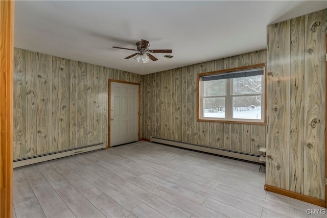 spare room with light hardwood / wood-style floors, ceiling fan, and baseboard heating