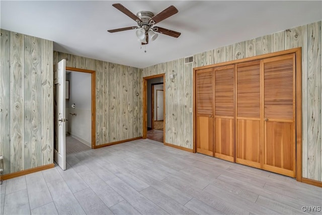 unfurnished bedroom featuring light hardwood / wood-style floors, a closet, and ceiling fan