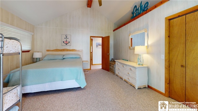 carpeted bedroom with ceiling fan, lofted ceiling with beams, and a closet