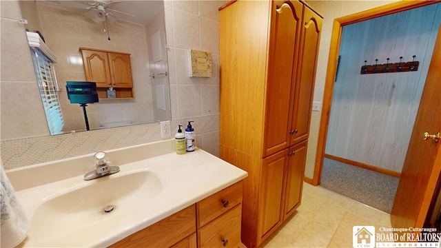 bathroom with tile floors, ceiling fan, tile walls, and large vanity