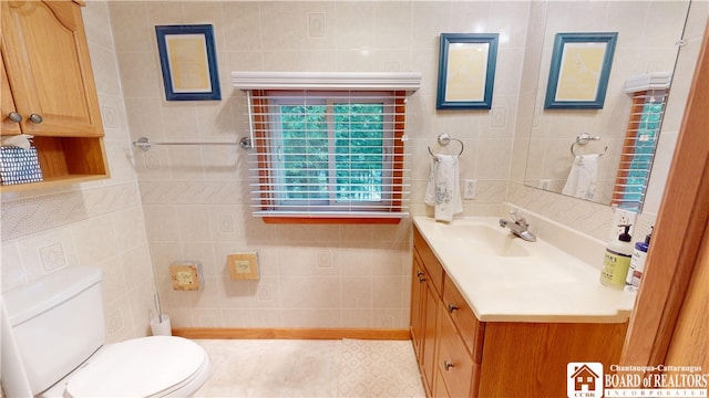 bathroom featuring tile walls, large vanity, and toilet