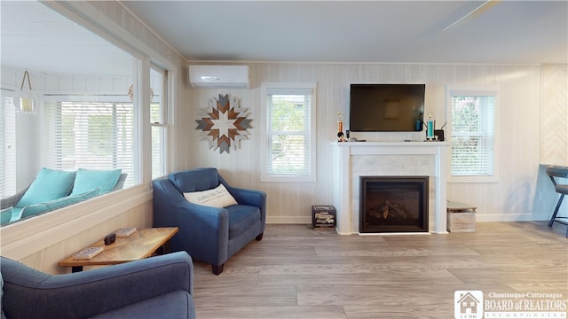 living room with a wealth of natural light, light hardwood / wood-style floors, and a wall mounted air conditioner