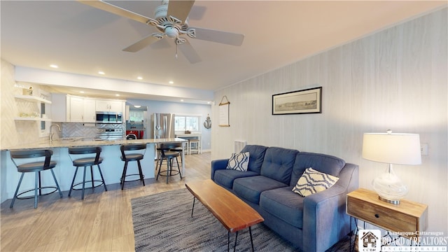 living room featuring ceiling fan and light wood-type flooring