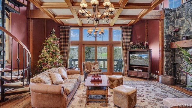 living area with hardwood / wood-style flooring, coffered ceiling, beamed ceiling, and an inviting chandelier