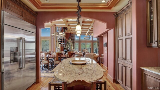 dining area featuring beam ceiling, light hardwood / wood-style floors, an inviting chandelier, and coffered ceiling