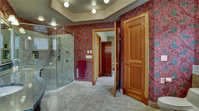 bathroom featuring tile patterned flooring, vanity, an enclosed shower, and toilet