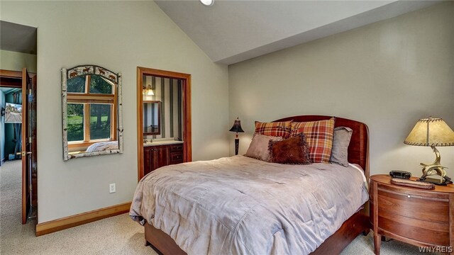 bedroom featuring ensuite bathroom, light colored carpet, and high vaulted ceiling