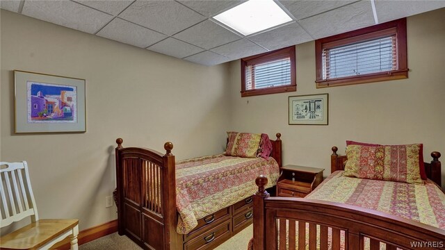 bedroom featuring carpet and a paneled ceiling