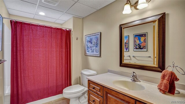 full bathroom with shower / bath combo with shower curtain, vanity, toilet, and a paneled ceiling