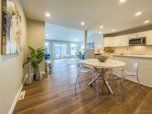 dining space with sink and dark wood-type flooring